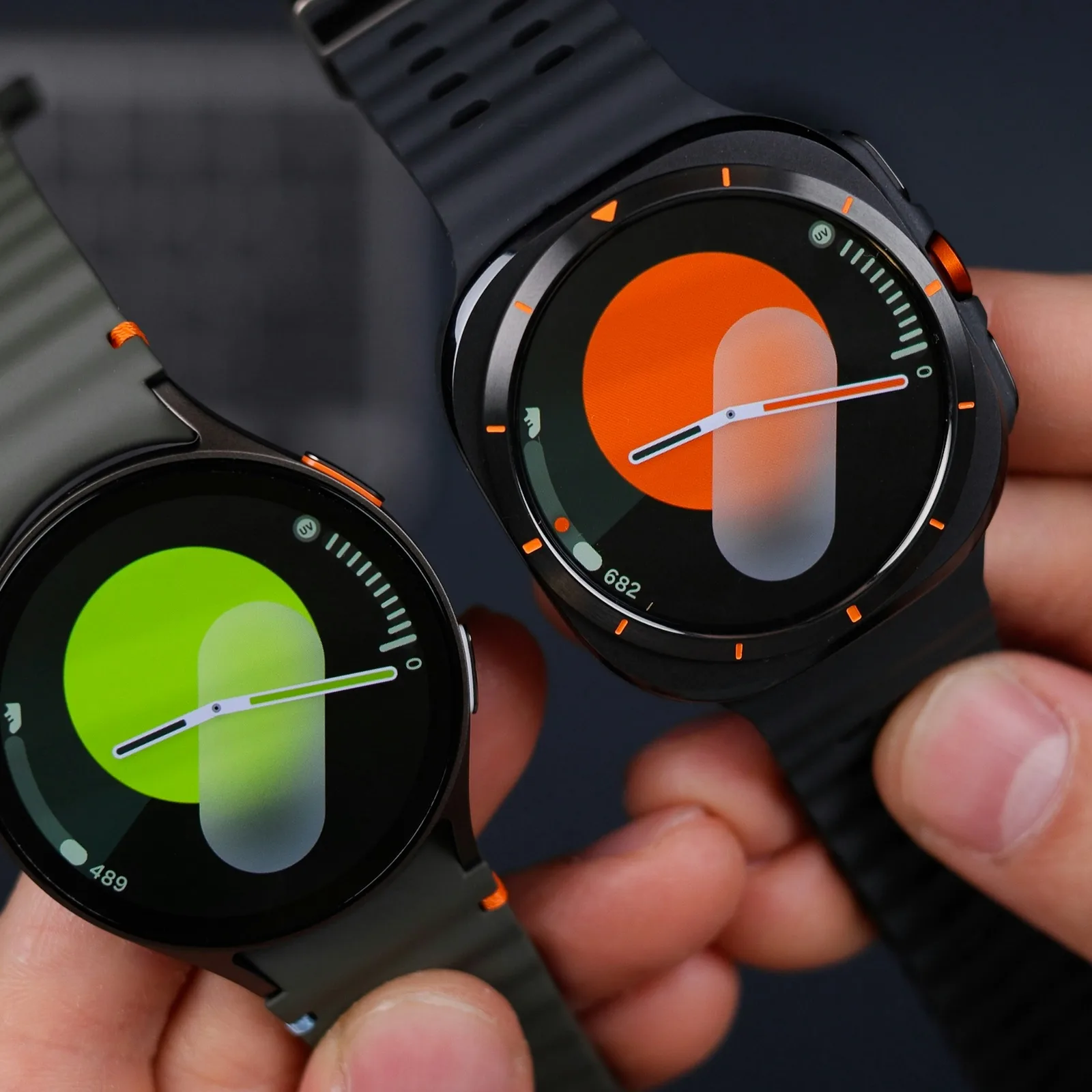Two powered-on Samsung Galaxy smartwatches held side by side