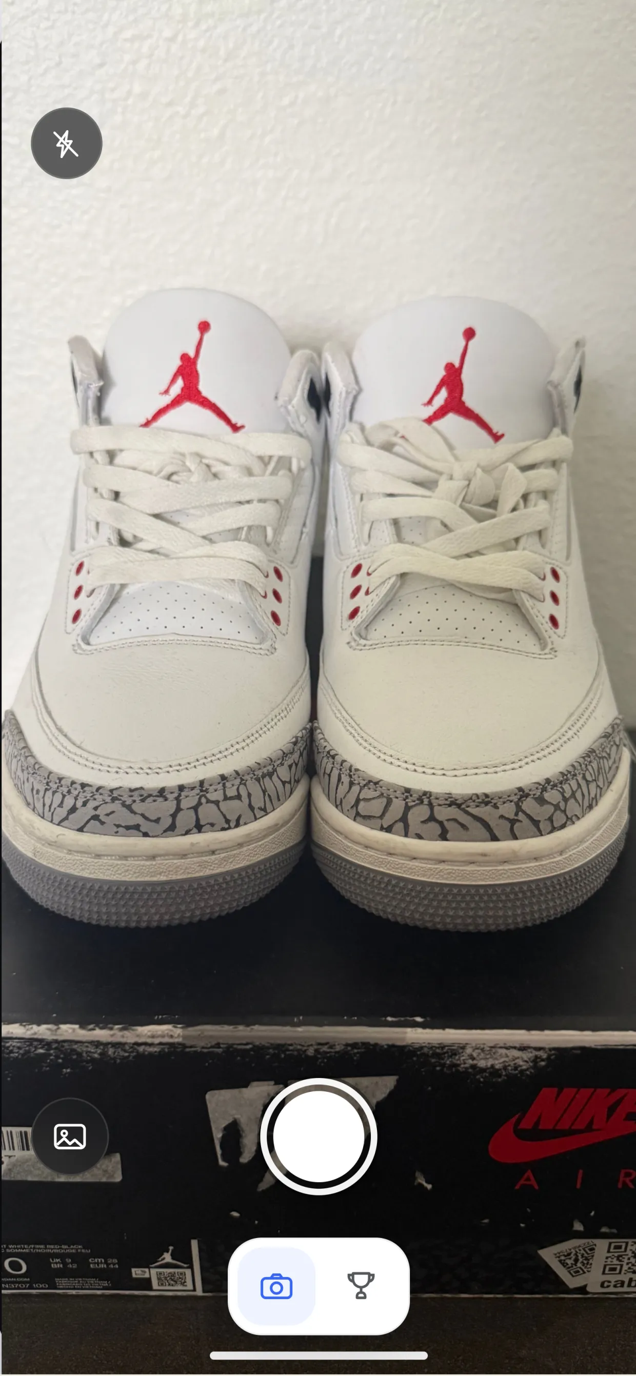 The SnapList camera pointed at a pair of Air Jordan 3 sneakers standing on their box, with the shutter and the photo library button below it.