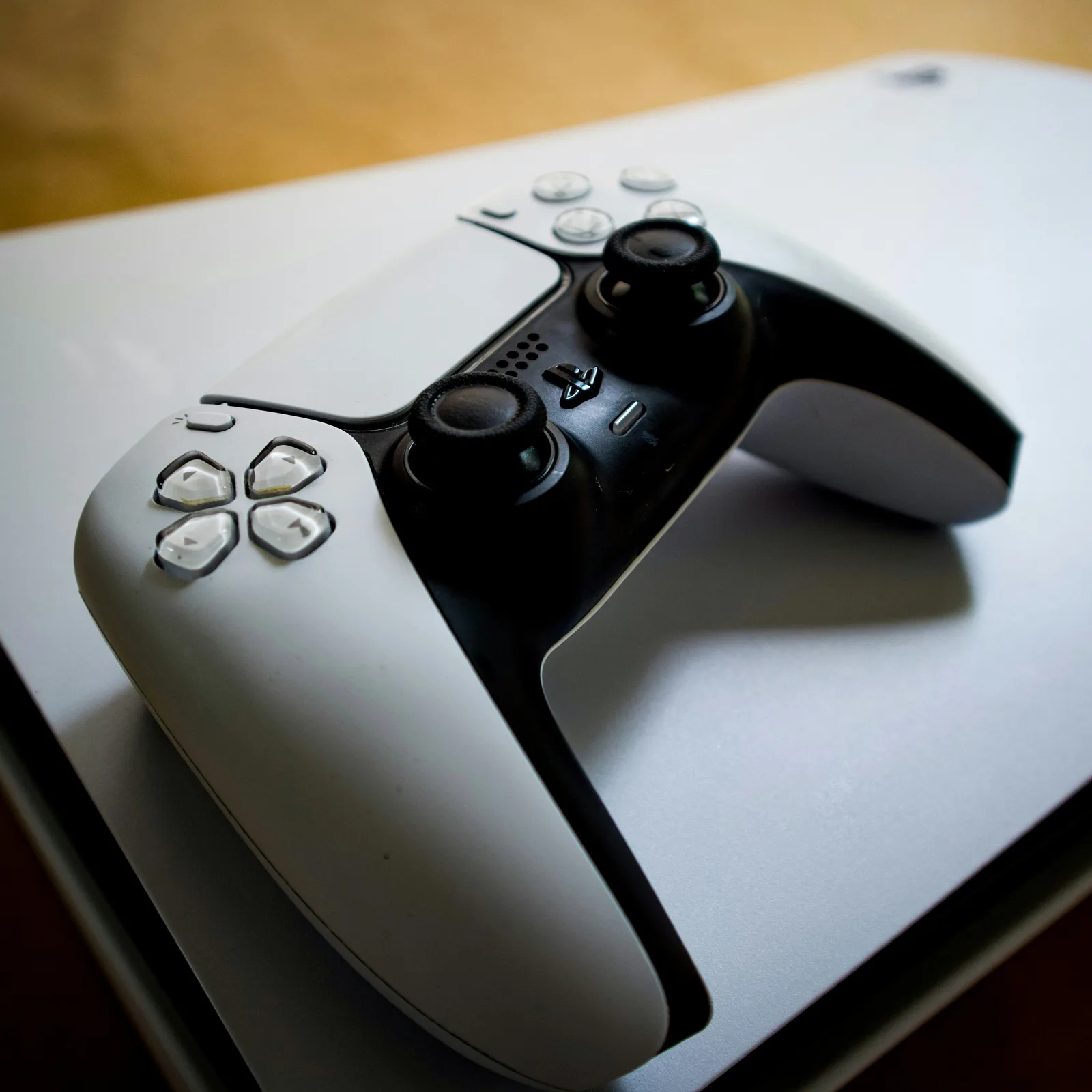White Sony PlayStation 5 console with a matching DualSense controller resting on top